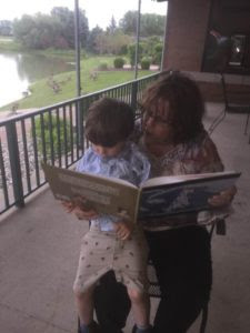 Parents are children's first teachers. The author reading to her grandson.